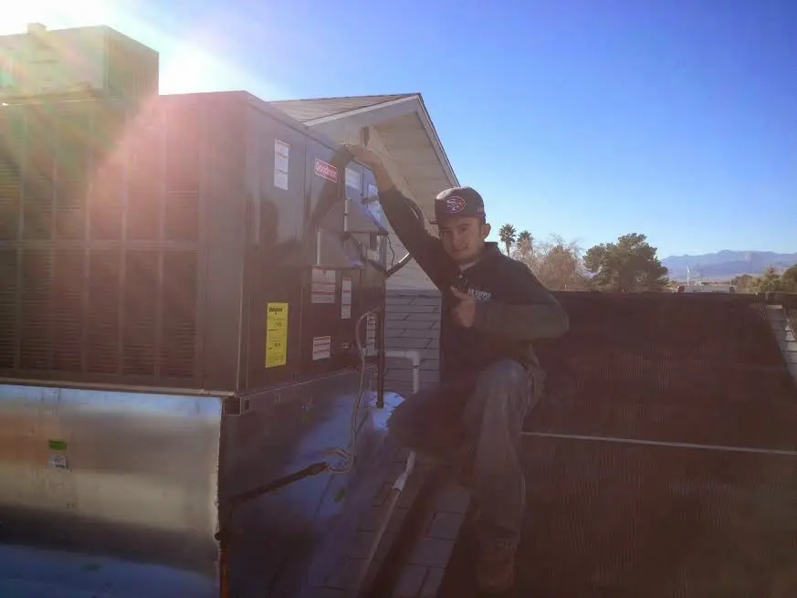 HVAC technician performing Boiler Repair on a rooftop unit in Berea